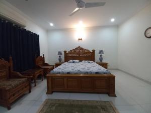 伊斯兰堡DHA 2 Villa, Near Giga Mall, Islamabad的一间卧室,卧室内配有一张床和椅子