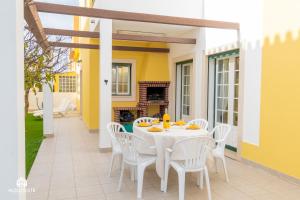 圣克鲁斯Santa Beach Villa - 3 bedrooms & BBQ的带壁炉的庭院配有白色桌椅