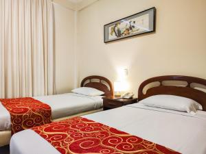 圣克鲁斯Hotel Lido的酒店客房设有两张床,墙上挂着一张照片。