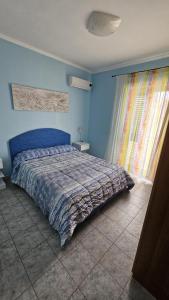 维耶斯泰Azienda Agricola Gentile - la casa degli ulivi的一间卧室配有一张蓝色墙壁的床