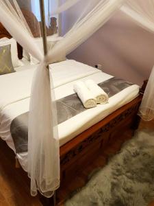 内罗毕Teresita Home的一张带白色床单和毛巾的床