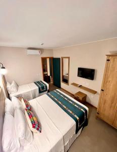 皮雷诺波利斯Resort Quinta Sta Bárbara的酒店客房设有两张床和一台平面电视。