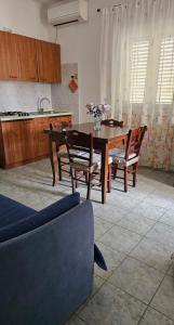 维耶斯泰Azienda Agricola Gentile - la casa degli ulivi的一间带桌椅的客厅和一间厨房