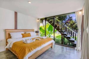 坎古Belvilla Seaside Hermitage Cosy Bungalow Canggu Beach的一间卧室设有一张床和一个大窗户