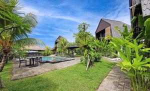 坎古Belvilla Seaside Hermitage Cosy Bungalow Canggu Beach的一个带游泳池和草地的度假庭院