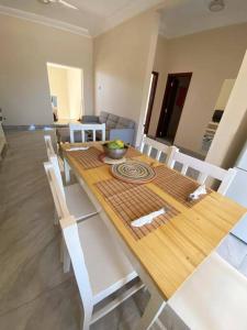 Sere KundaKMR Apartment - Sira的餐桌、白色椅子和木桌