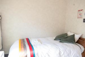 俱知安町Niseko Powder Chalet的卧室配有白色床和2个绿色枕头