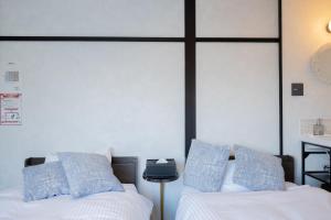 俱知安町Niseko Powder Chalet的一间卧室配有两张带蓝白色枕头的床
