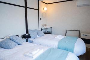 俱知安町Niseko Powder Chalet的酒店客房设有两张床和墙上的时钟。