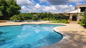 马那瓜New 3 bedroom Home in Managua的庭院里的一个蓝色海水游泳池