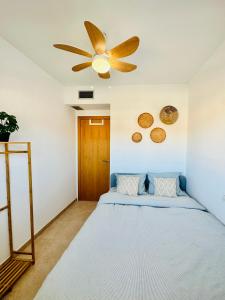 迈阿密普拉特亚Apartamento con Piscina y Jardín Fantástico Cala Sirenas - Nuevo的一间卧室配有一张床和吊扇