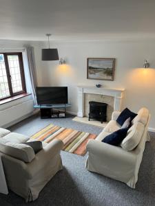 谢林汉姆SeaCross Sheringham Norfolk Coast 3 Bed Detached house的客厅设有两张沙发和一个壁炉