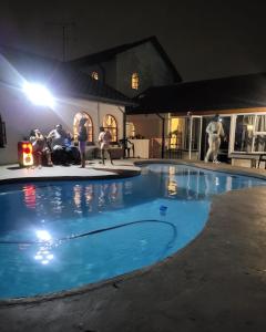 约翰内斯堡Sky view Guest House的一群人晚上坐在游泳池周围