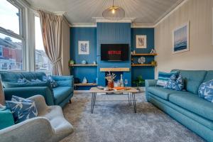 朴次茅斯Modern 2-Bed Stylish Contractor House, Prime Portsmouth Location & Parking - By Blue Puffin Stays的蓝色的客厅配有蓝色的沙发和桌子
