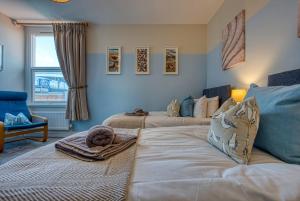 朴次茅斯Modern 2-Bed Stylish Contractor House, Prime Portsmouth Location & Parking - By Blue Puffin Stays的一间带两张床和一张沙发的客厅