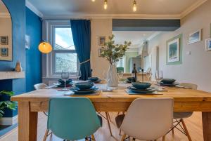 朴次茅斯Modern 2-Bed Stylish Contractor House, Prime Portsmouth Location & Parking - By Blue Puffin Stays的用餐室配有大型木桌和椅子