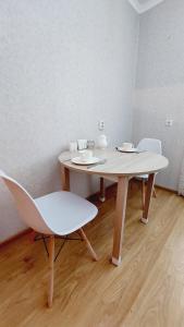 PrigorodnyyАэропорт Астана的配有桌椅的木地板客房