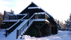 PłocicznoSiedlisko Dzika Kaczka的雪上雪下的房屋