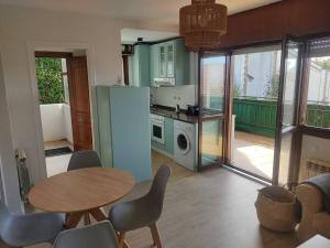莫格罗Apartamento en Mogro.的厨房配有桌椅和冰箱。