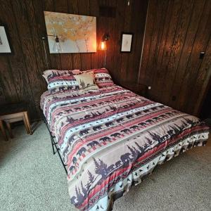 ChampionAlpine Retreat @ Seven Springs!的卧室内的一张床铺,设有木墙