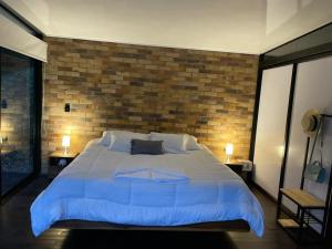 拉维加La ceiba cabaña的一间卧室设有一张带砖墙的大床