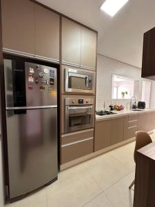 新弗里堡Apartamento familiar no centro em Nova Friburgo的厨房配有不锈钢冰箱和微波炉。