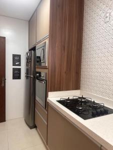 新弗里堡Apartamento familiar no centro em Nova Friburgo的厨房配有炉灶和冰箱。