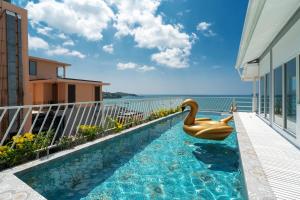 Ban Ao Makhammona seaview pool villa beach front AoYon Beach的阳台上的游泳池,上面有天鹅浮动