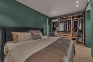 特罗姆瑟Villa Aurora View的一间卧室设有一张带绿色墙壁的大床