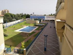 塞维利亚Estudio Lux-Palacio de Congresos的从带游泳池的大楼的阳台上可欣赏到风景