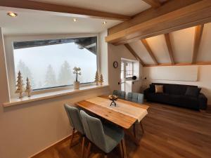 翁特陶埃恩扎恩莱腾公寓的客厅设有木桌和大窗户。