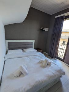第比利斯Guesthouse Chrdili的卧室配有带毛巾的大型白色床