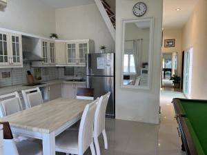 南芭堤雅芭提雅享受泳池别墅Enjoy Pool Villa的厨房配有桌椅和冰箱。