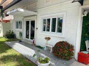 南芭堤雅芭提雅享受泳池别墅Enjoy Pool Villa的前院带长凳的白色房子