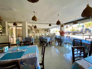韦拉克鲁斯Hotel Playa de Oro - Enfrente de WTC y Plazas Comerciales的餐厅设有蓝色的桌椅和窗户。