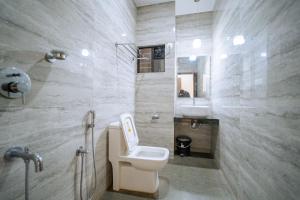 阿贡达Darsy Residency的一间带卫生间、水槽和镜子的浴室