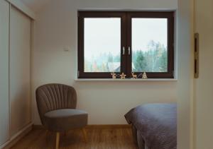 斯克拉斯卡波伦巴Domek na szlaku的一间卧室配有椅子和窗户