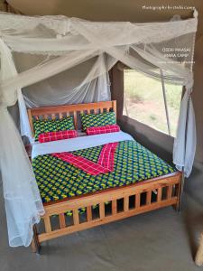 NarokOseki Maasai Mara Camp的一张木床,位于一个房间的天篷里