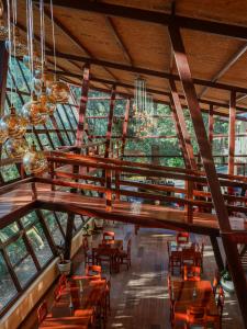 QuillabambaEcoterra Inka Lodge的餐厅设有木桌、椅子和窗户。