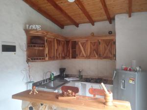 麦德林alto palmas 2.0的厨房配有木制橱柜、水槽和冰箱。