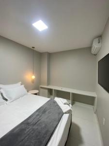 阿拉亚尔-杜卡布Casa Amora的一间卧室配有一张床、一张书桌和一台电视
