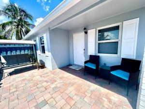 西棕榈滩Gorgeous & Convenient Apartment Near Airport的一个带蓝色椅子的庭院和一座房子