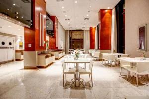 巴西利亚Flat Particular no Comfort Suites的一间设有白色桌子和白色椅子的餐厅