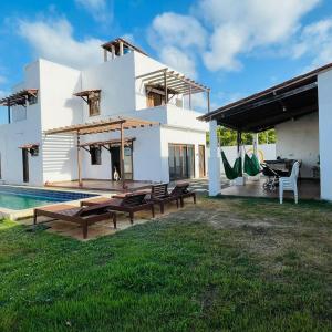 日若卡-迪热里科阿科阿拉Pousada Casa Paraiso的一座白色的房子,在庭院里设有一个游泳池
