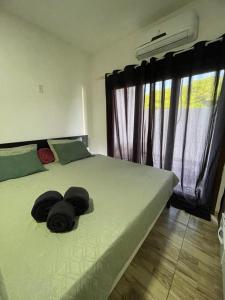 日若卡-迪热里科阿科阿拉Pousada Casa Paraiso的一间卧室,配有一张带两顶帽子的床