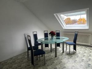 美因河畔法兰克福GardenApartment的一间设有玻璃桌和椅子的用餐室