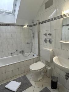 美因河畔法兰克福GardenApartment的浴室配有卫生间、浴缸和水槽。