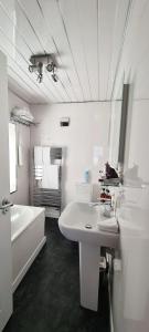罗撒西Cadillac Kustomz Hotel的白色的浴室设有浴缸、水槽和镜子