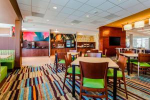 佩科斯Fairfield Inn & Suites by Marriott Pecos的一间带桌椅和电视的用餐室
