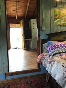 RochesterThe Hunter Cabin at Sky Hollow的一间卧室配有一张床,一扇门通往厨房